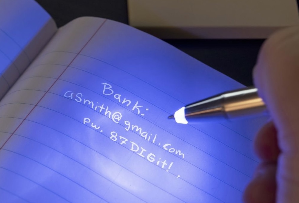 Image of bank details written in invisible ink, but hovered over a UV light.