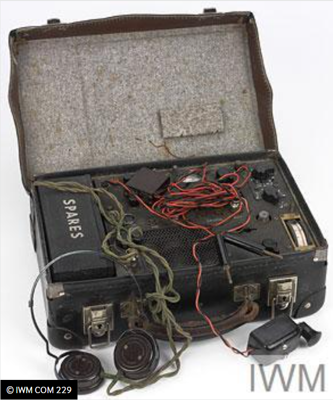 Suitcase with a radio inside of it. A lot of wires, a headset and a microphone.