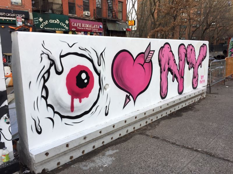 Graffiti that says I love NewYork, but the letter I is depicted with an eyeball, and the love is represented by an animated heart