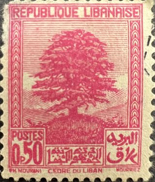 A pink postage stamp that has the Cedars of Lebanon representing Lebanon.