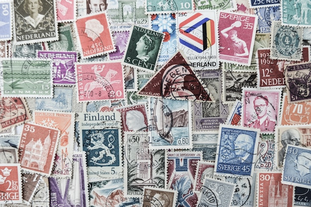 An image that shows a bunch of postage Stamps that are collected Fracross many different countries. 